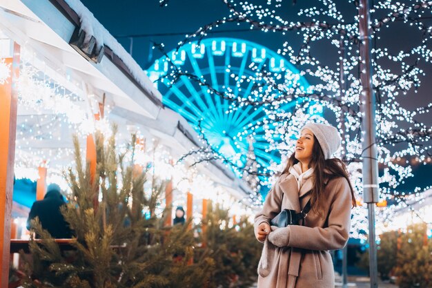 Fille posant dans le contexte des arbres décorés