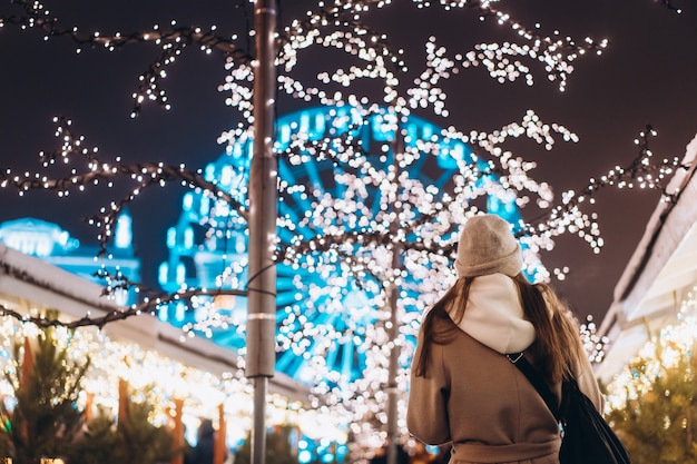 Fille posant dans le contexte des arbres décorés