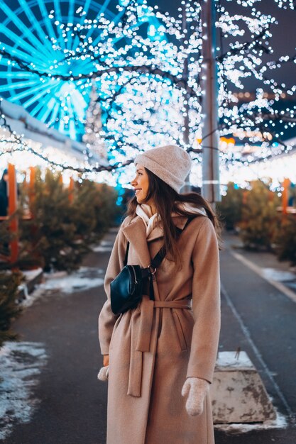 Fille posant dans le contexte d'arbres décorés