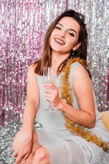 Fille posant avec du champagne à une fête du nouvel an