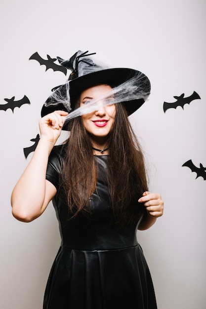 Fille posant avec web sur un chapeau