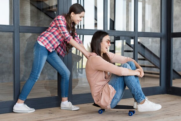 Fille poussant maman sur planche à roulettes