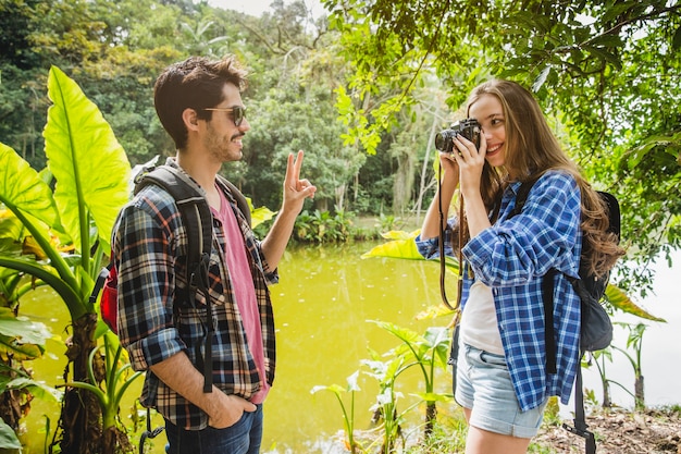 Fille prenant une photo de petit ami dans la jungle