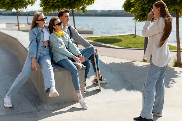 Photo gratuite fille prenant une photo de ses amis à l'extérieur