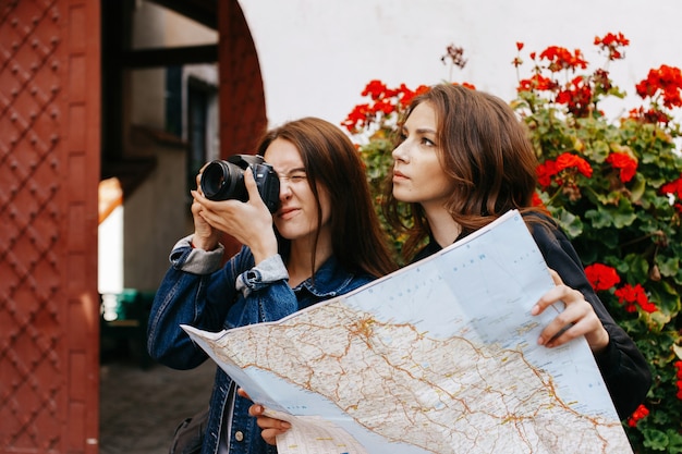 Une fille prend une photo tandis qu&#39;une autre regarde la carte touristique