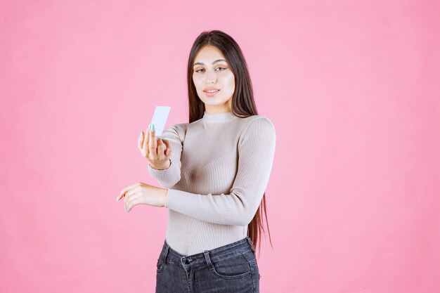 Fille présentant sa carte de visite à un partenaire commercial