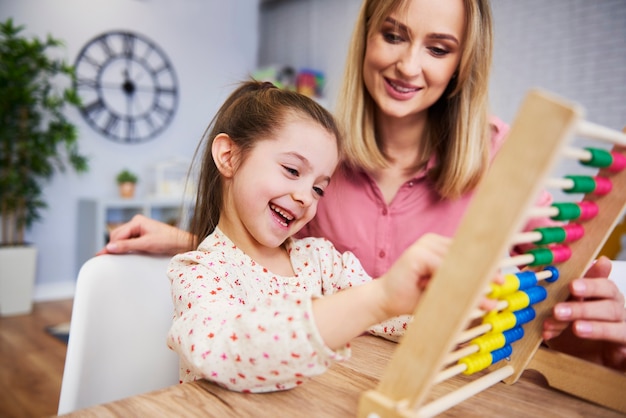 Fille et professeur à l'aide d'un boulier pendant l'école-maison