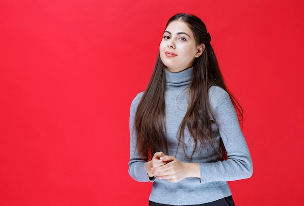 Fille en pull gris donnant des poses positives et attrayantes.