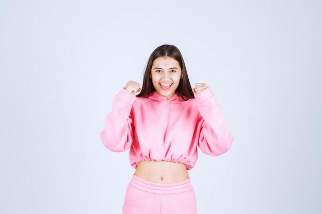 Fille en pyjama rose est une gagnante et montre ses poings