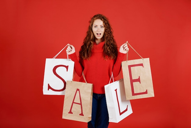 Photo gratuite fille qui crie avec des sacs à provisions au studio shot