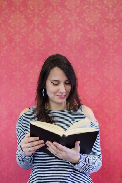 Une fille qui lit un livre à la maison.