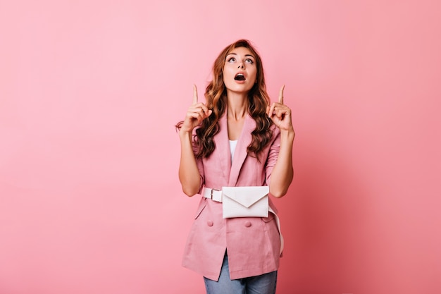 Photo gratuite fille raffinée aux cheveux ondulés au gingembre en levant. dame bien habillée étonnée posant avec la bouche ouverte.