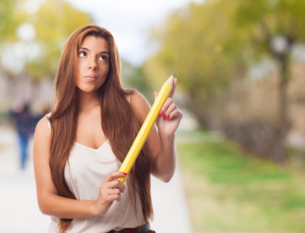 fille Réfléchi avec un crayon dans la main