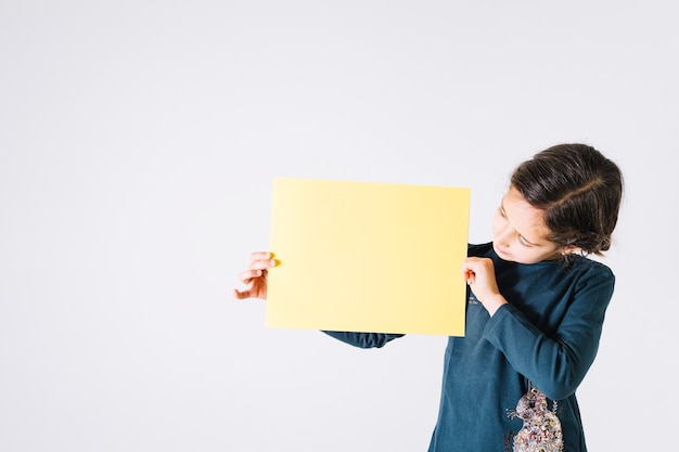 Fille regardant une feuille de papier