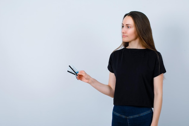 La fille regardant à gauche tient des cartes de crédit sur fond blanc