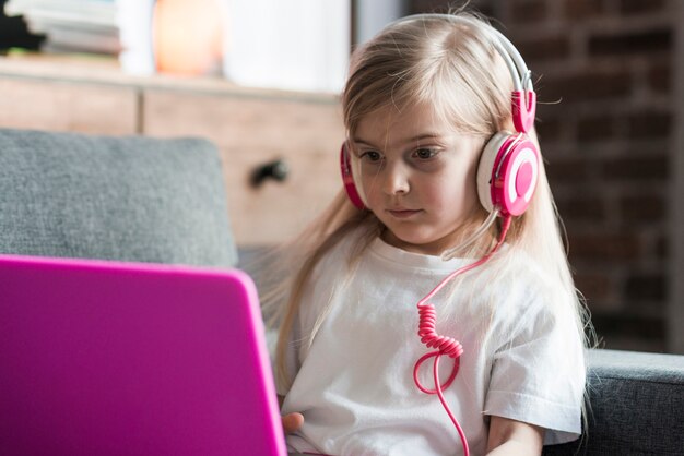 Fille regardant un ordinateur portable rose