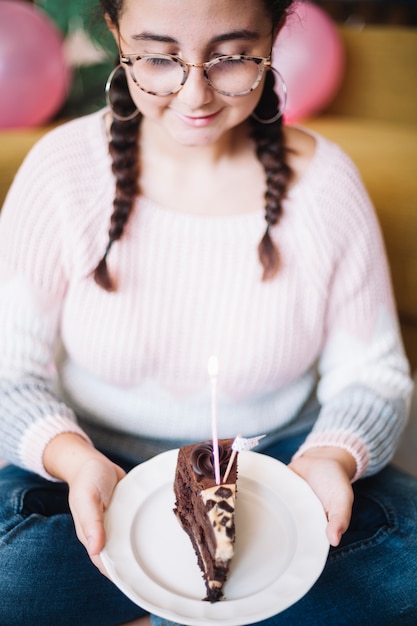 Fille regardant une tranche de gâteau