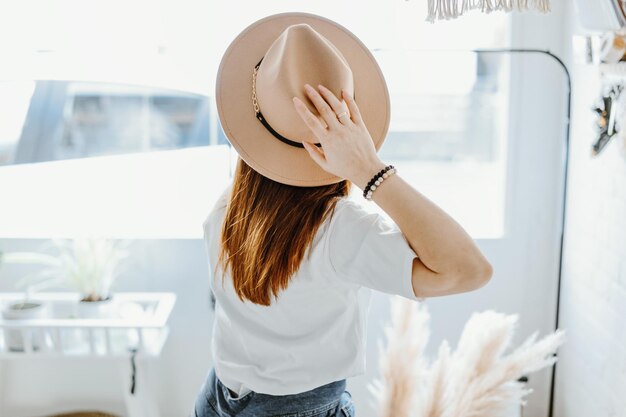 Fille relaxante relaxante dans un chapeau dans une pièce lumineuse