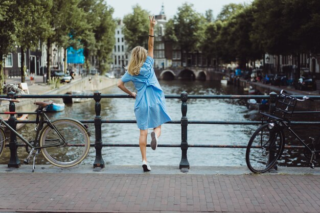 fille en robe bleue sur le pont à Amsterdam