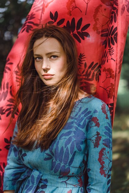 fille en robe en lin. avec une guirlande de fleurs sur sa tête.