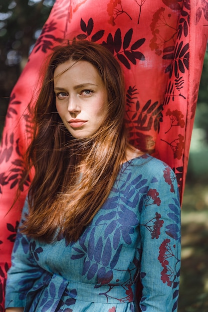 fille en robe en lin. avec une guirlande de fleurs sur sa tête.