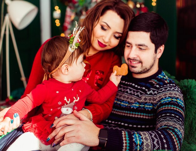 Fille en robe rouge tend la main avec cookie à son père