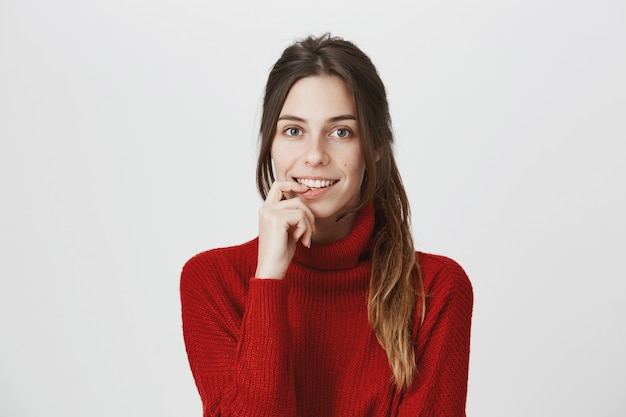 Fille romantique touchant la lèvre et souriant