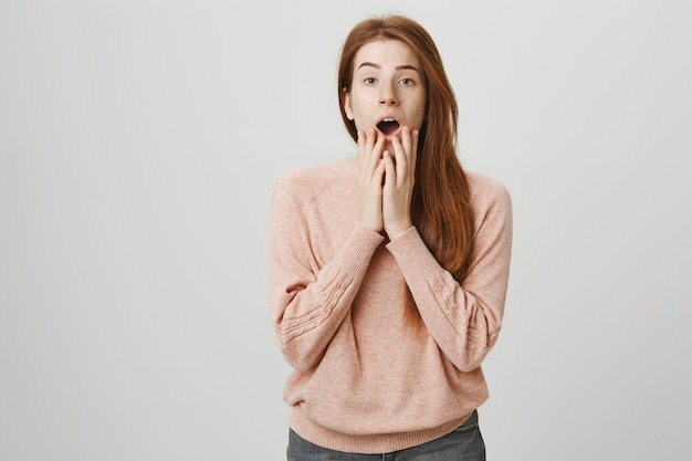 Fille rousse choquée haletante, l'air inquiète