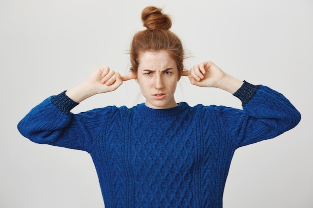 Photo gratuite fille rousse en colère ferme les oreilles ne voulant pas écouter