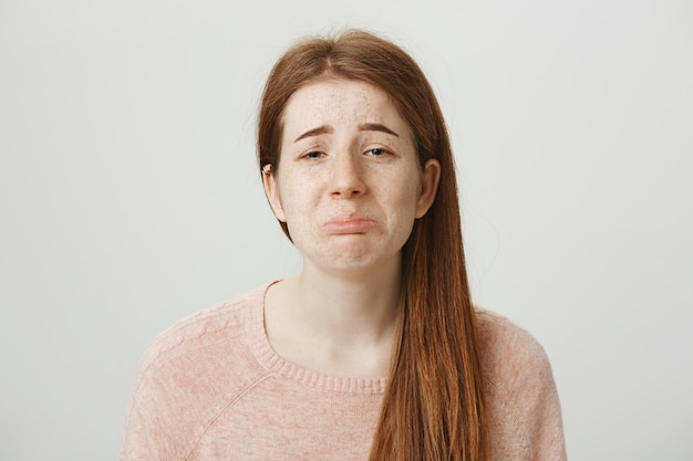 Fille rousse pleurnicharde sombre sanglotant et faisant la moue réticente