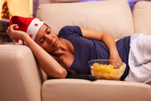 Fille s'endormir sur un canapé dans une cuisine décorée de Noël