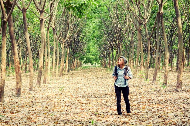 Fille avec sac à dos en regardant les arbres