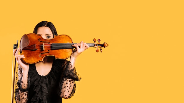 Fille se cachant derrière le violon