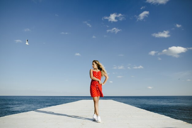 une fille se dresse sur une couchette et regarde la mer