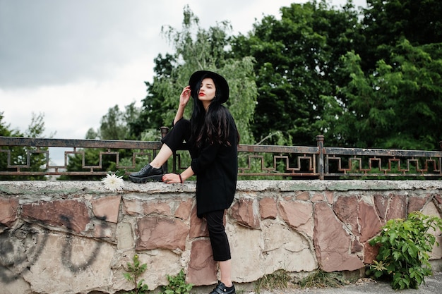 Fille sensuelle tout en lèvres rouges noires et chapeau Goth femme dramatique