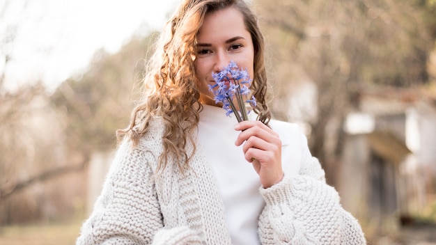 Photo gratuite fille sentant de belles fleurs sauvages