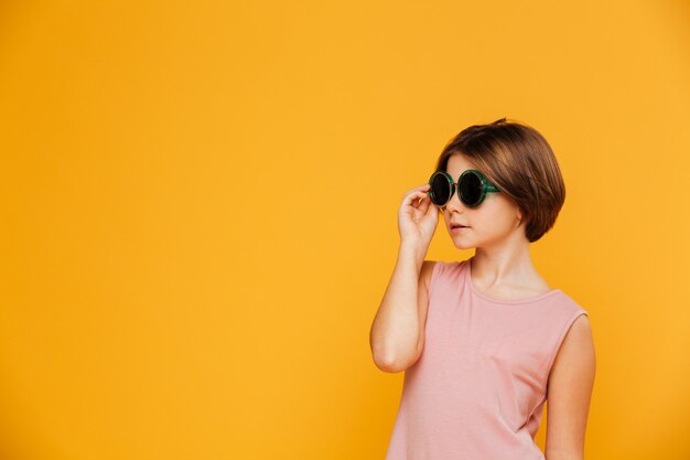 Fille sérieuse confiante en lunettes de soleil à côté