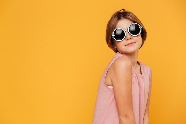 Fille sérieuse confiante en lunettes de soleil à côté