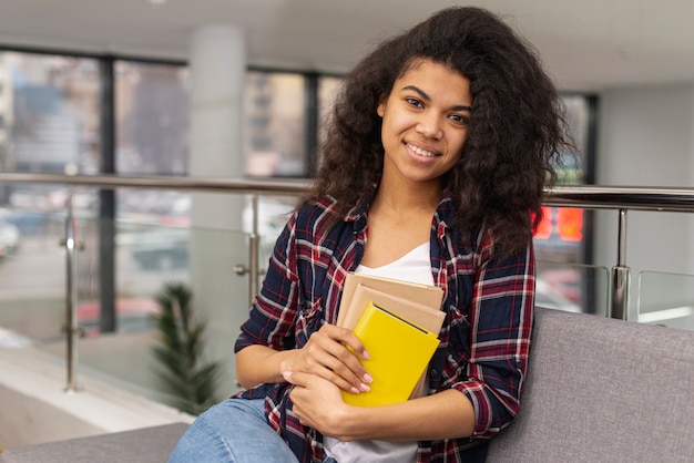 Fille de Smiley avec pile de livres