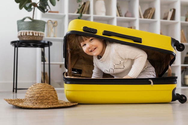 Photo gratuite fille de smiley plein coup assis dans les bagages