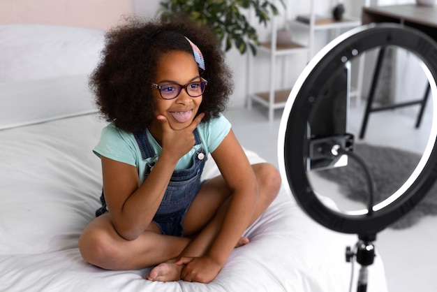 Fille souriante à angle élevé enregistrant une vidéo