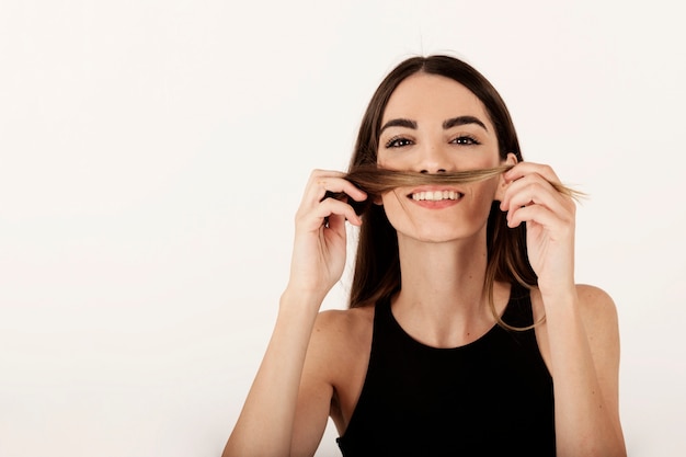 Photo gratuite une fille souriante blague avec ses cheveux