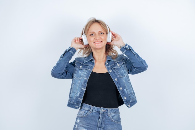 Une fille souriante avec un casque lève les yeux sur fond blanc