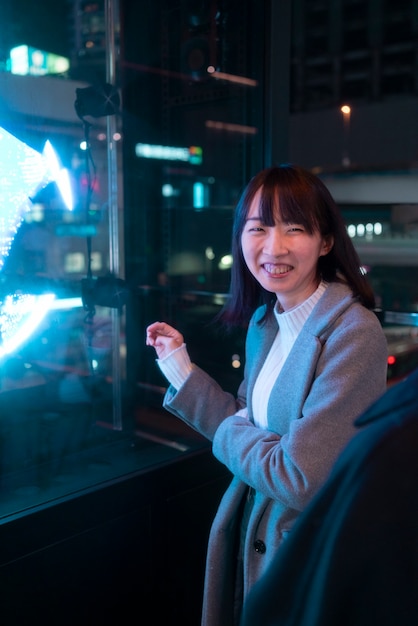 Fille souriante à coup moyen la nuit