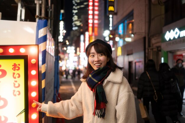 Fille souriante à coup moyen pointant vers le signe