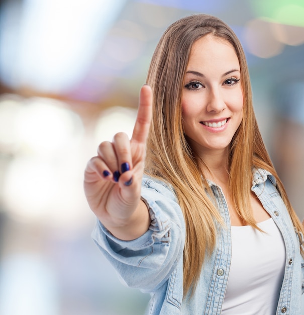 Photo gratuite fille souriante avec un doigt vers le haut