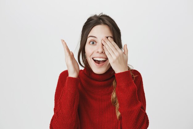 Fille souriante excitée, yeux ouverts, attendez-vous à la surprise