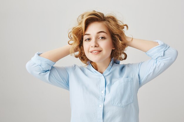 Fille souriante heureuse après avoir fait une nouvelle coupe de cheveux bouclés