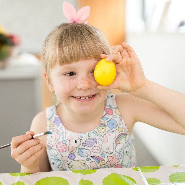 Fille souriante et posant avec oeuf