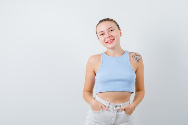 fille souriante pose à la caméra sur fond blanc